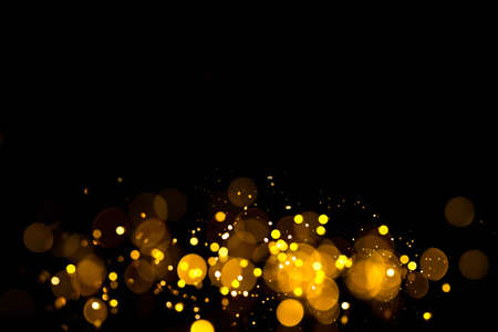 Golden abstract bokeh on black background. Holiday conceptの写真素材
