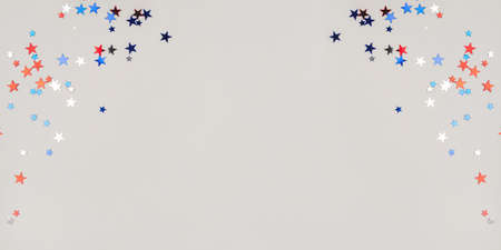 Festive background with confetti in the shape of stars in the color of the American flag. US independence day.の写真素材