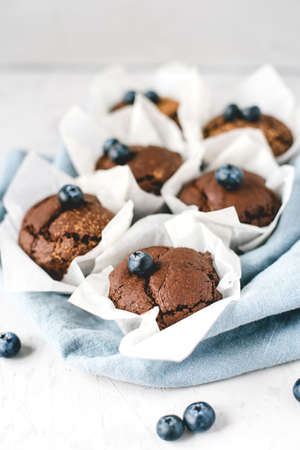 Homemade fresh chocolate muffins with berries and chocolate pieces. Front view.の写真素材