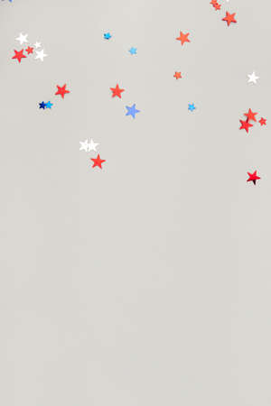Festive background with confetti in the shape of stars in the color of the American flag.の写真素材