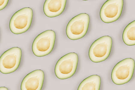 Pattern of fresh green avocado on a grey background. Top view.