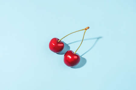 Ripe cherry berries on a blue background. Flat lay, top view.