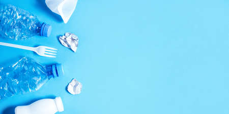 Plastic trash on blue background. Eco concept image with copy space.の写真素材