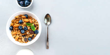 Baked granola with yogurt and blueberries on a gray table. Top view. Banner with copy space for text.の写真素材