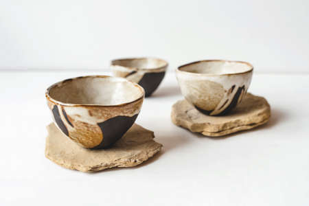 Handmade ceramics in the style of wabi sabi. Brown clay bowls with an abstract pattern.の写真素材