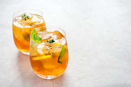 Iced tea with ice, mint and lemon. Refreshment cold summer drink.の写真素材