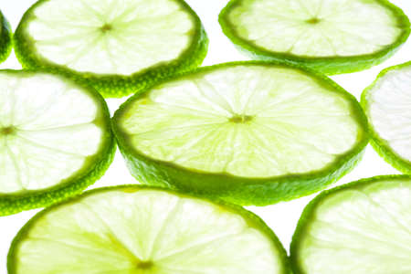 Green lime slices isolated on white background. Food texture.の写真素材