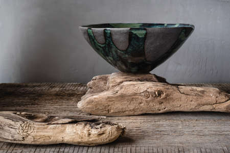 Handmade ceramics in the style of wabi sabi. Grey clay bowl with an abstract green pattern.の写真素材