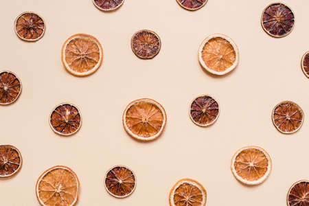 Dried orange and lime slices. A natural snack. Pastel background. Flat lay, top view.の写真素材