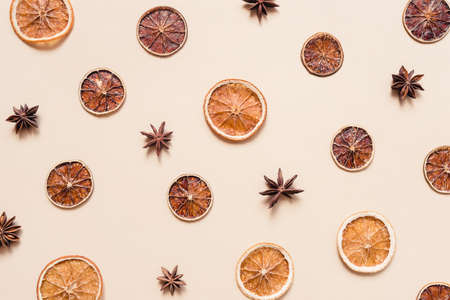 Dried orange and lime slices and anise stars. Spices for the cold season. Pastel background. Flat lay, top view.の写真素材