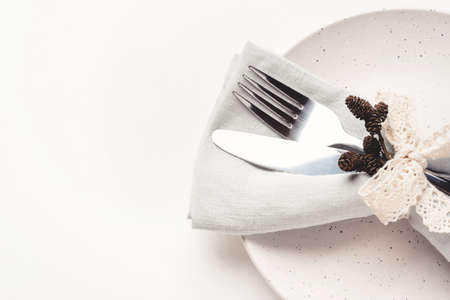 Beautiful set of cutlery knife and fork on a plate on a white wooden table. Concept of Thanksgiving, Christmas, or other holiday. Copy space for text.の写真素材