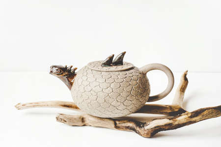 Ceramic teapot handmade with a spout in the form of a dragon on white background.の写真素材