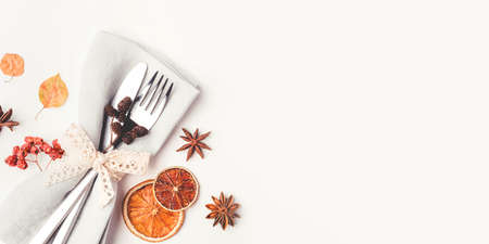 Thanksgiving autumn background. Plate with Cutlery and napkin decorated with autumn leaves, berries and spices. Top view.の写真素材