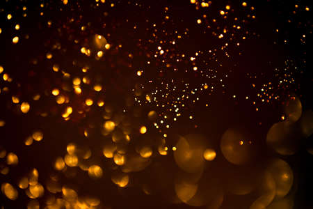 Golden abstract bokeh on black background. Holiday conceptの写真素材