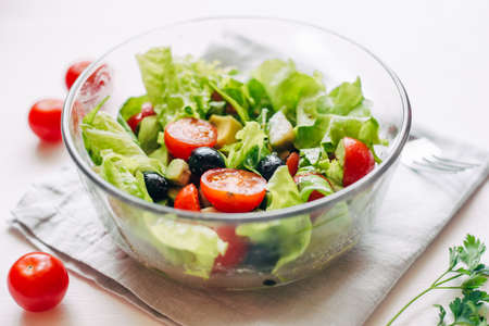 Fresh salad of avocado, cherry, arugula and olives made at home. Vegan food. The concept of healthy eating. Front view.の写真素材