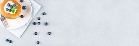 A stack of pancakes with fresh blueberries and cheesecream. Top view. Copy space for text.の写真素材