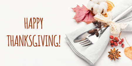 Thanksgiving autumn background. Plate with Cutlery and napkin decorated with autumn leaves, berries and spices. Front view. Close up.の写真素材