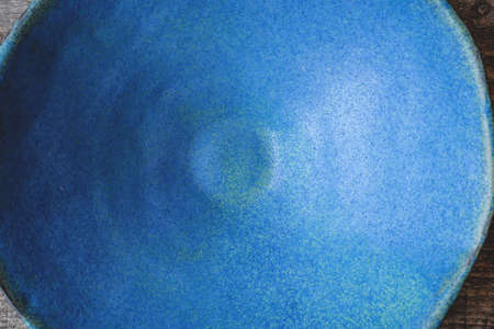 Handmade ceramics in the style of wabi sabi. Blue clay bowl with an abstract pattern. Top view.の写真素材