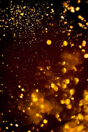 Golden abstract bokeh on black background. Holiday conceptの写真素材