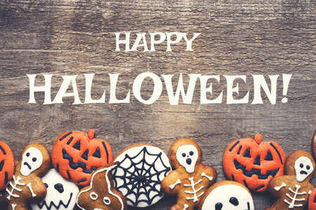 Halloween gingerbread cookies on wooden background. Flat lay. Copy space for your text.の写真素材