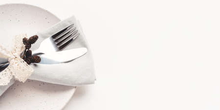 Beautiful set of cutlery knife and fork on a plate on a white wooden table. Concept of Thanksgiving, Christmas, or other holiday. Copy space for text.の写真素材