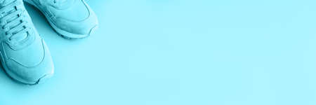 Sneakers on a blue background. A trending monochrome image for your design. Copy space for text. Toned image.の写真素材