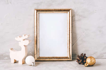 Golden photo frame and christmas decorations on gray background. Christmas, winter, new year concept. Copy space for text.の写真素材