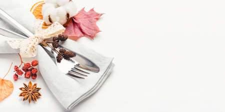 Thanksgiving autumn background. Plate with Cutlery and napkin decorated with autumn leaves, berries and spices. Front view. Close up.の写真素材