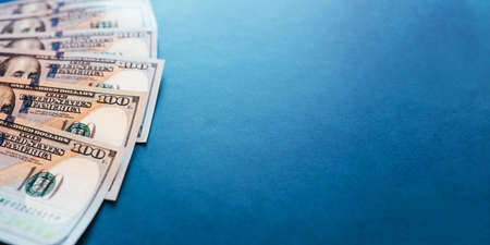 American cash dollars. One Hundred Dollar Banknotes on blue background. Copy space.の写真素材