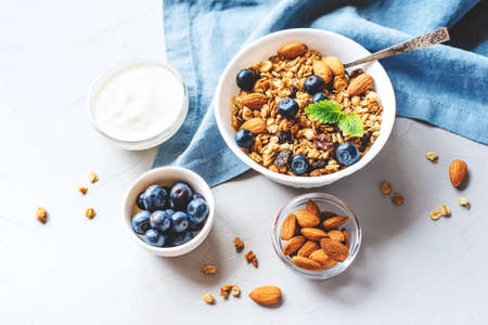 Baked granola with yogurt and blueberries on a gray table.の写真素材