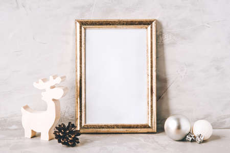 Golden photo frame and christmas decorations on gray background. Christmas, winter, new year concept. Copy space for text.の写真素材