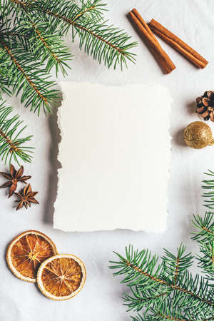 Greeting card for Christmas or New Yaer made of fir branche, spices and dried oranges and a cone with paper card note. Flat lay.の写真素材