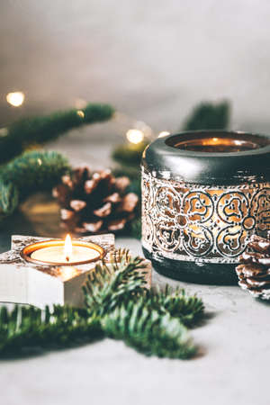 Christmas composition of candlesticks, fir branches and garland on gray background.の写真素材
