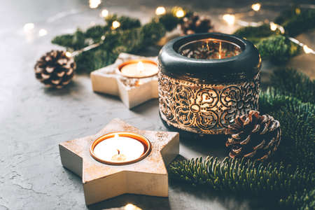 Christmas composition of candlesticks, fir branches and garland on gray background.の写真素材