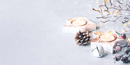 A composition of candlesticks, snow branches and Christmas decorations on gray background.の写真素材