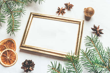 Greeting card for Christmas or New Yaer made of fir branche, spices and dried oranges and a cone with golden frame.の写真素材