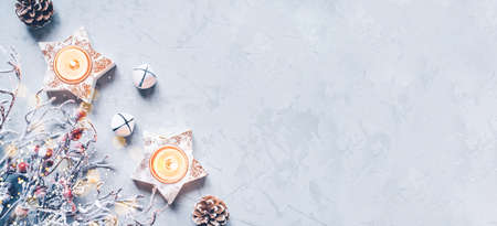 A composition of candlesticks, snow branches and Christmas decorations on gray background.の写真素材