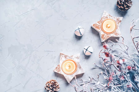 A composition of candlesticks, snow branches and Christmas decorations on gray background.の写真素材