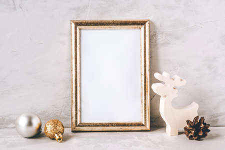 Golden photo frame and christmas decorations on gray background. Christmas, winter, new year concept. Copy space for text.の写真素材