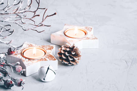 A composition of candlesticks, snow branches and Christmas decorations on gray background.の写真素材