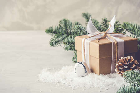 Christmas gift box in the snow on gray background. Christmas decor, winter mood, holiday decoration.の写真素材
