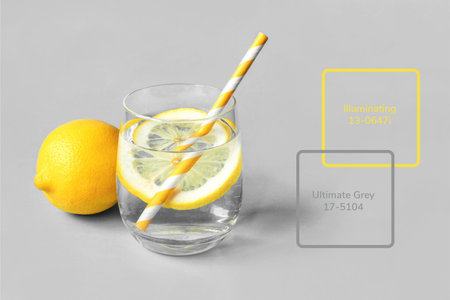 A glass of lemonade with lemon on a gray background. Colors 2021.の写真素材