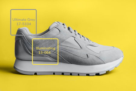 Gray sneaker on a yellow background. A trending image for your design. Colors 2021.の写真素材