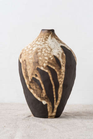 Handmade ceramics in the style of wabi sabi. Brown clay vase with an abstract pattern.の写真素材