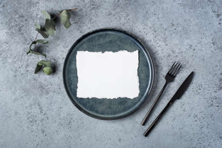 An empty plate and cutlery on a gray table. Top view.の写真素材