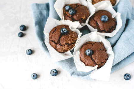 Homemade fresh chocolate muffins with berries and chocolate pieces. Front view.の写真素材