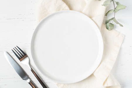 An empty plate and cutlery on a white wooden table. Top view.の写真素材