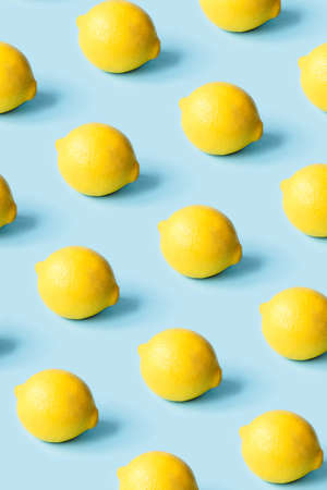 Pattern of ripe lemons on a blue background. Summer concept.の写真素材