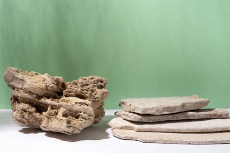 Background for cosmetic products of natural green color. Stone podium on a green background. Front view.の写真素材