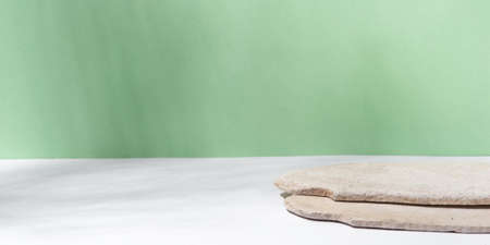 Background for cosmetic products of natural green color. Stone podium on a green background. Front view.の写真素材